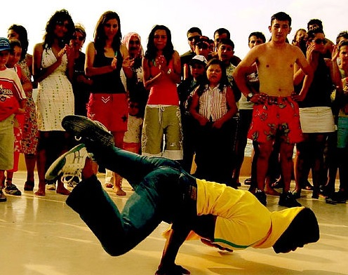 A dancer performing a street dance in front of a crowd. 