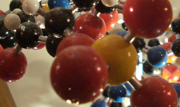 A molecular model shows hundreds of atoms, represented by yellow, red, black, blue and white balls.